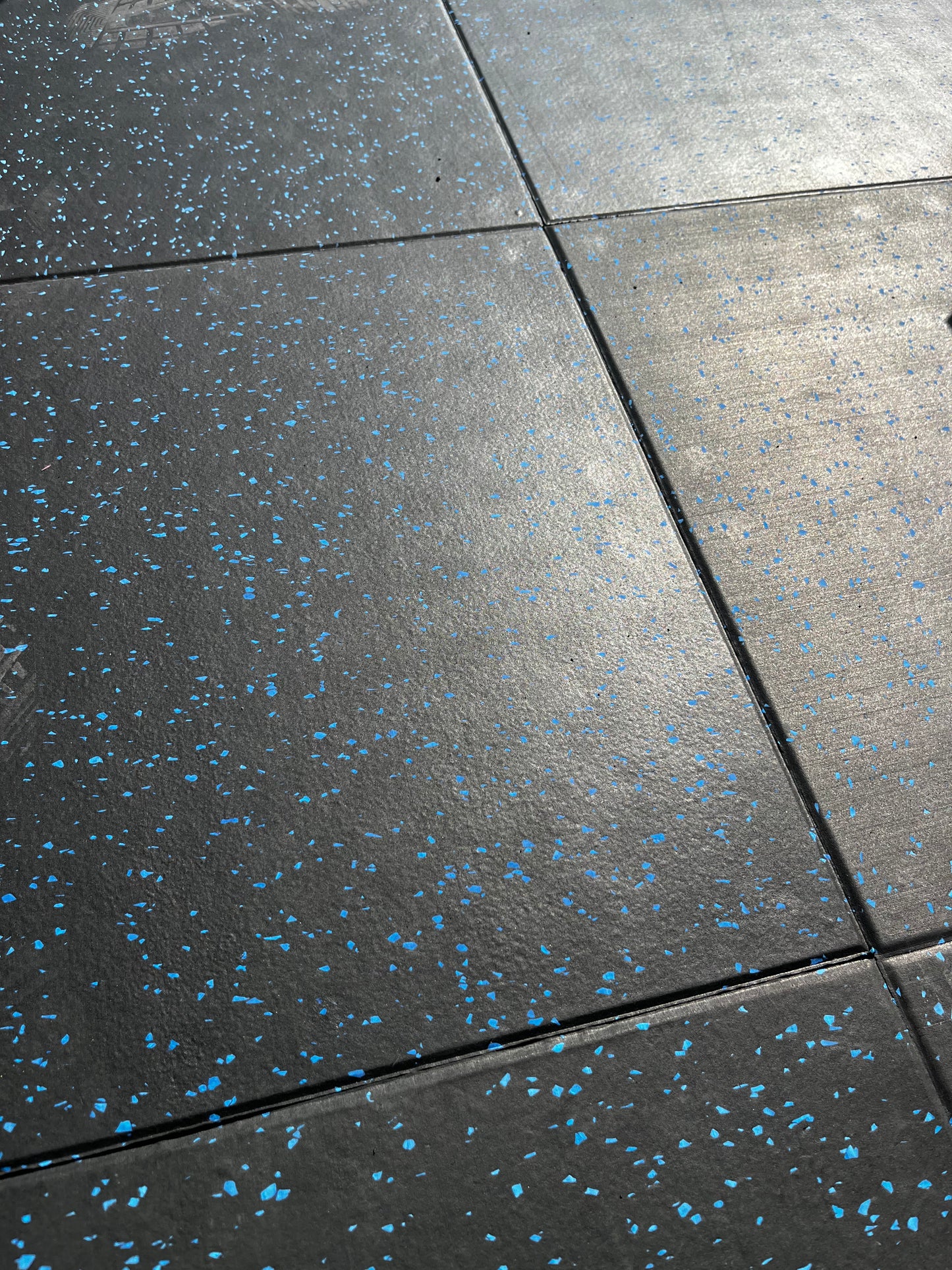 piso de caucho para gimnasio sodimac instalado en forma de losetas o baldosas negras con chispado azul